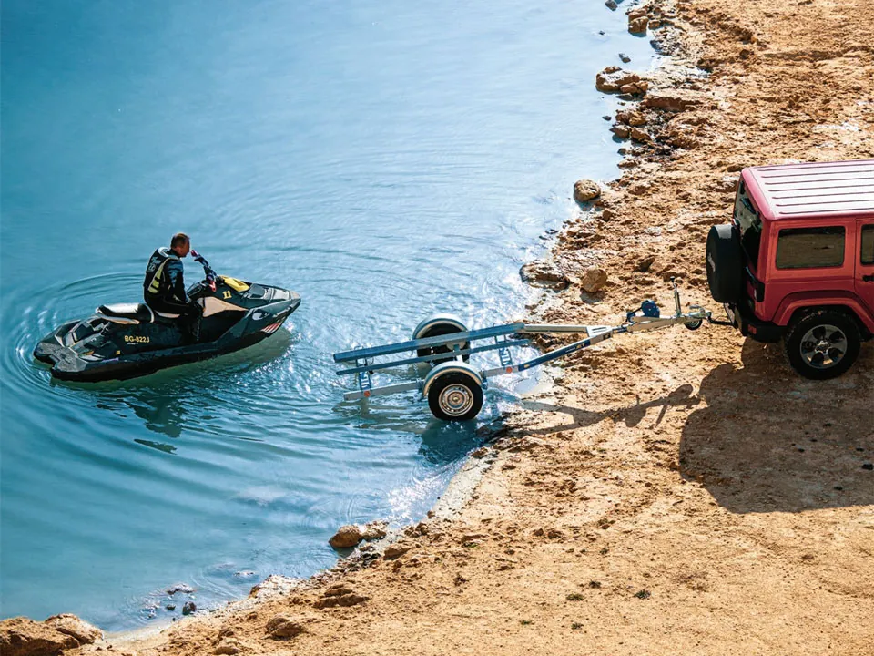 Personal watercraft on a trailer beside the water